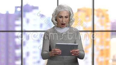 令人兴奋的<strong>老奶奶</strong>在她的平板电脑上玩游戏。